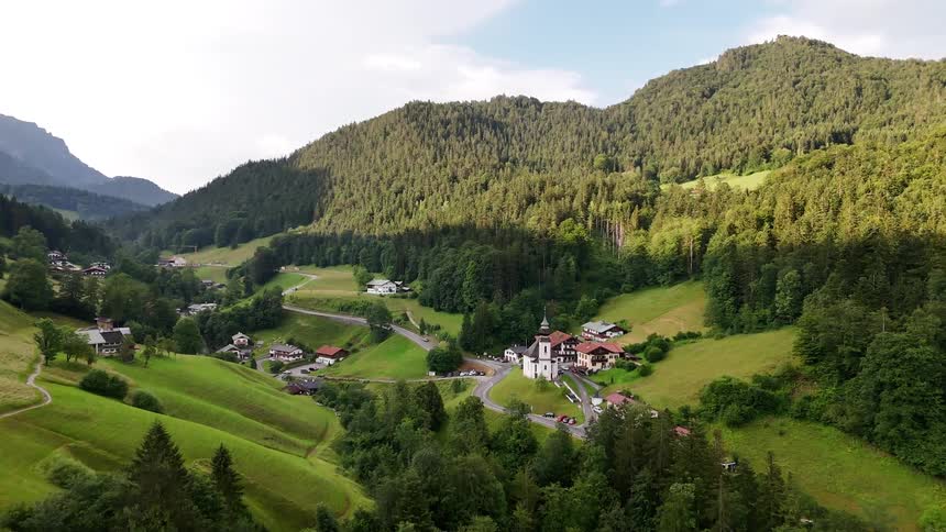 Aerial panorama of a village in the middle of wooded mountains