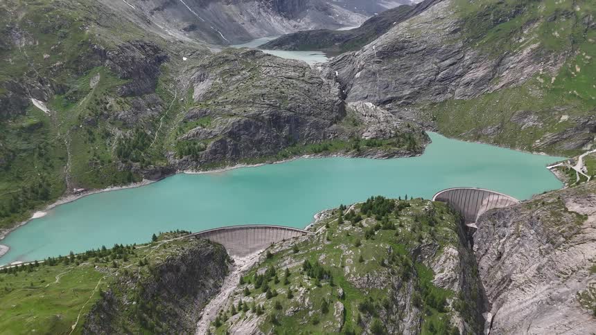 A dam on a lake with bluegreen water in a mountainous region