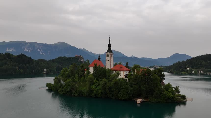 An aerial view of a building situated on an island in the middle of lake bled slovenia