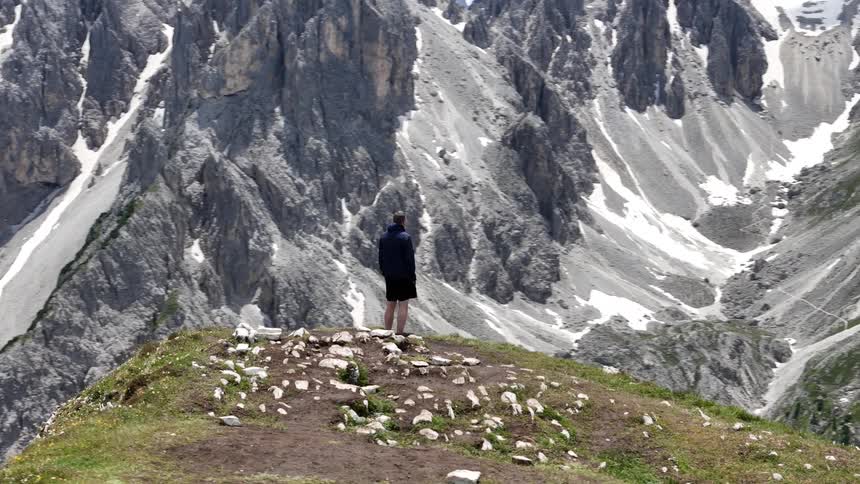 Man on a cliff in a mountainous valley
