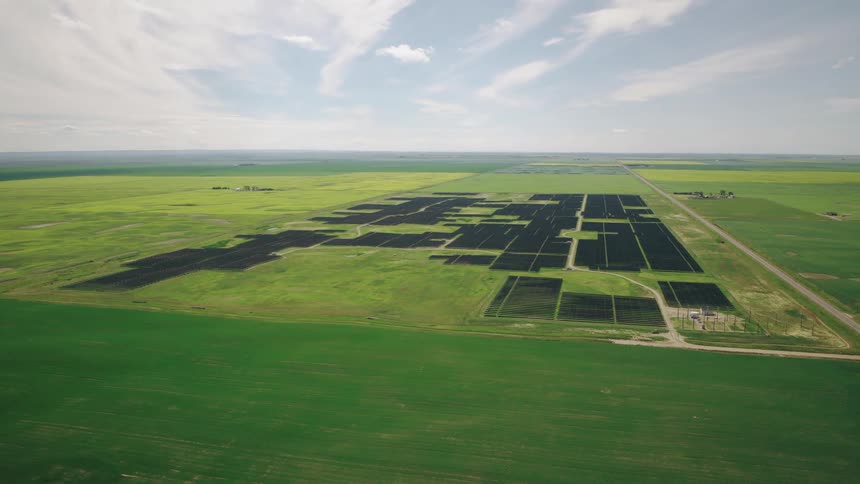 A highway passes a large solar farm on the prairie