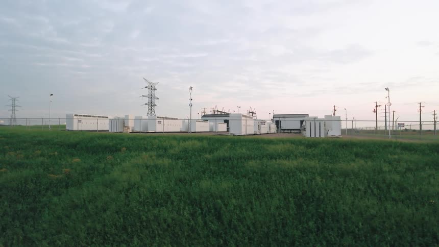 Green grass is in front of the power plant