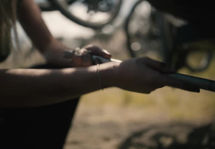 A woman turns a metal rod with her hands
