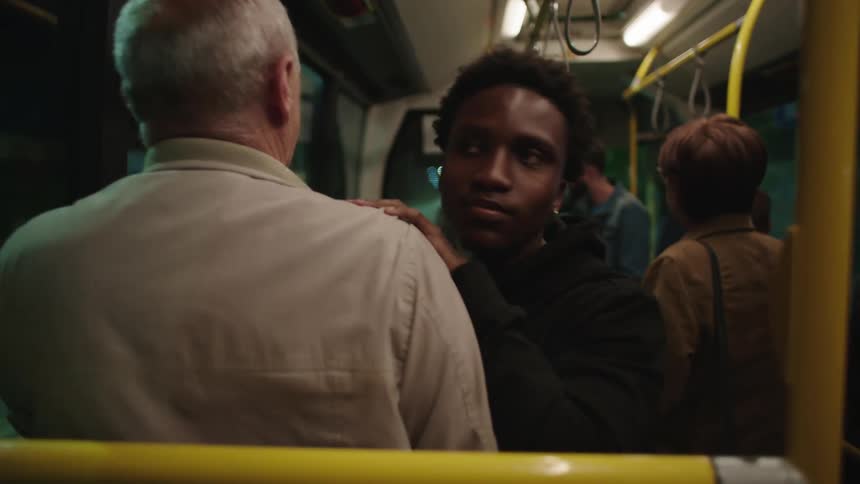 People inside a bus that brakes and one man bumps into another