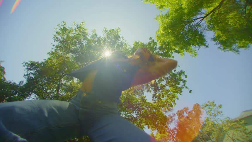 A woman dancing between the trees in her backyard