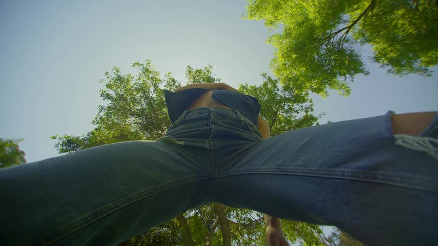 Blonde woman wearing jeans and a blue blouse dancing in a natural environment