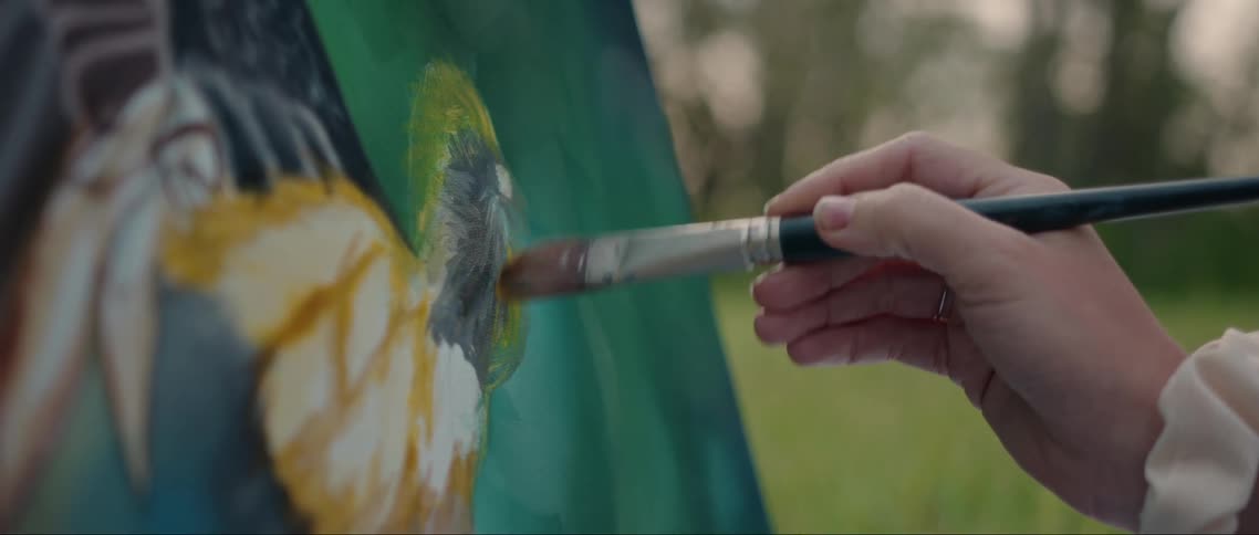 A woman is painting on the canvas