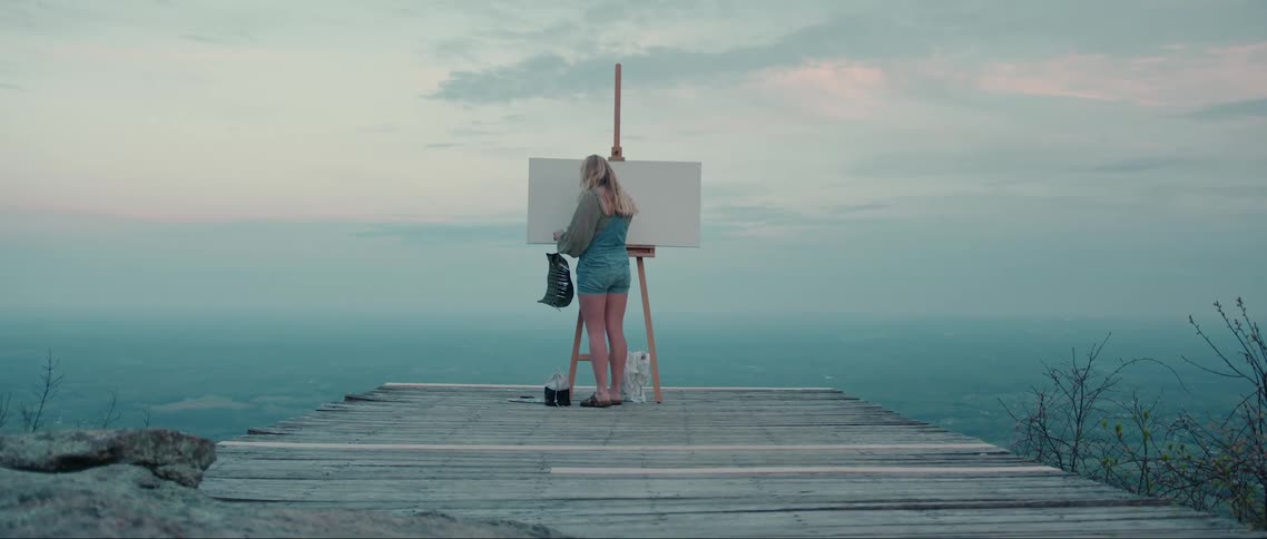 A woman sets up her canvas on the pier