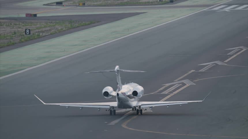 A white commercial plane is taking off from an asphalt runway