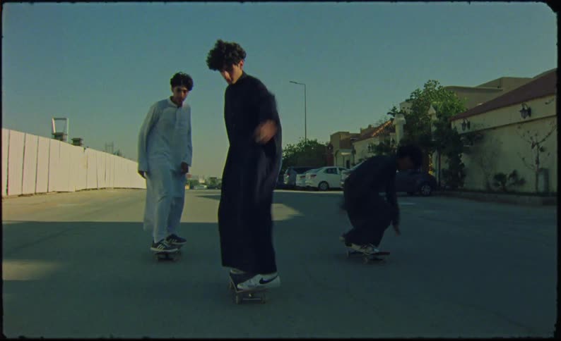 Skateboarders gracefully glide down a neighborhood street