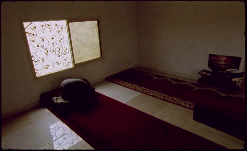 Person kneeling in a temple and lowering their head in prayer