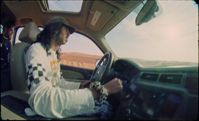 A man is driving in the desert