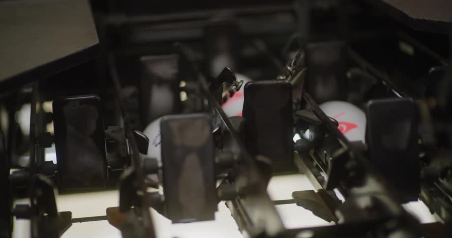 The bowling pins are moving down in the black metal machine