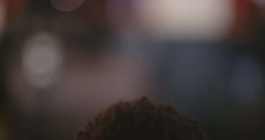 A young man stands up and smiles