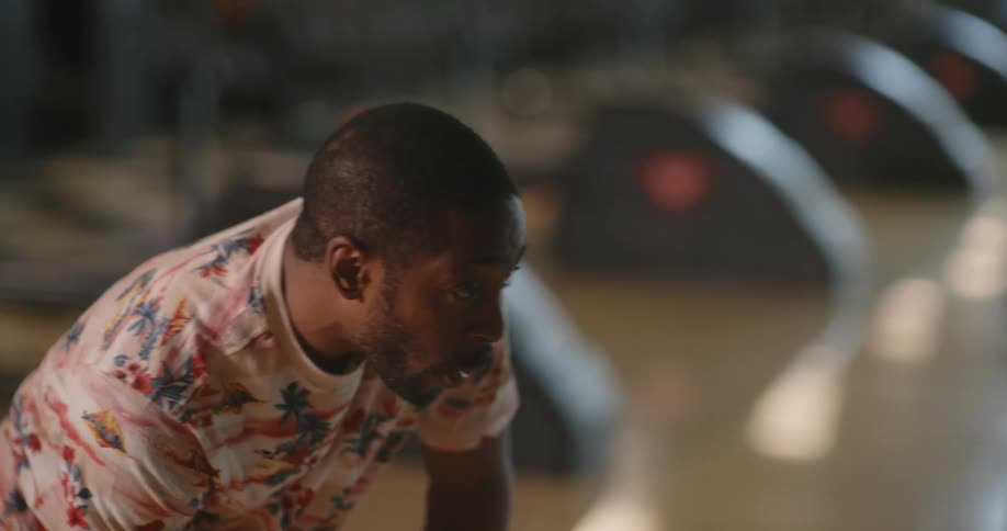 A man cheers after throwing the bowling ball