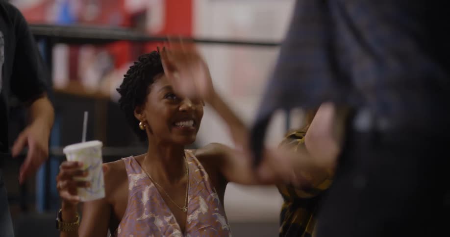 Two women cheer on a guy inside of a building
