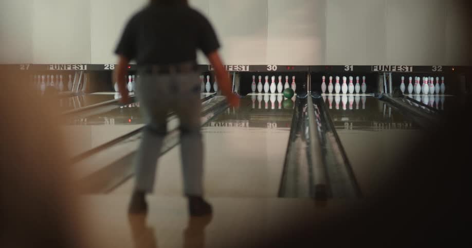 Man throwing a ball in a bowling game and cheering