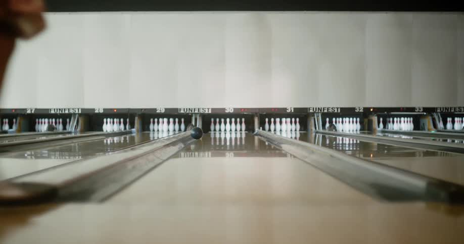 A woman throws a gutter ball