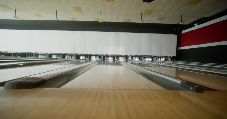 Womans legs in motion throwing a bowling ball on the court