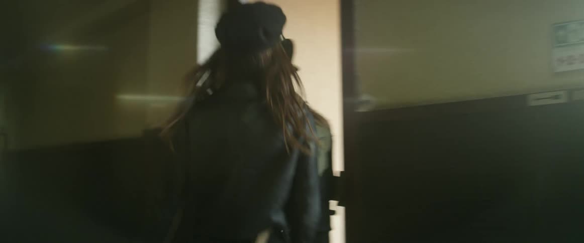 A man and a woman hold hands while rushing up the stairs of a building