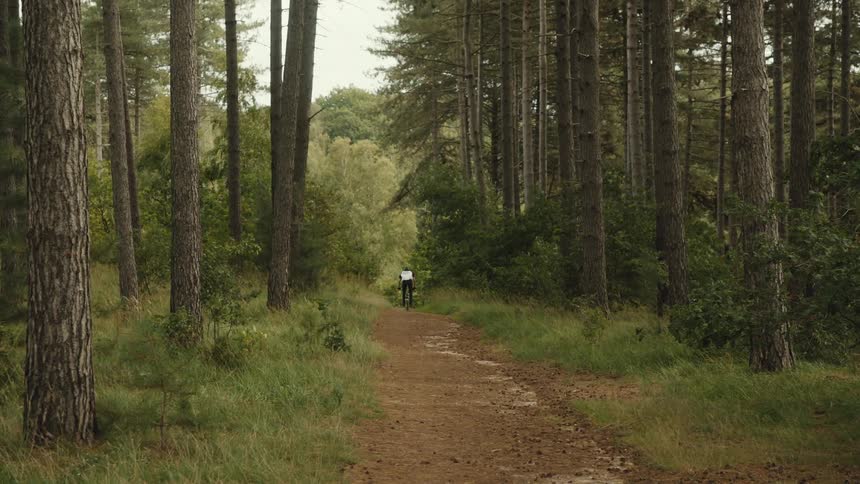 A man rides his bike down a dirt path