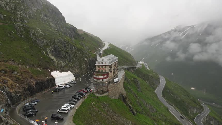 Aerial view of a building on a mountain hill with highways around it on a cloudy day