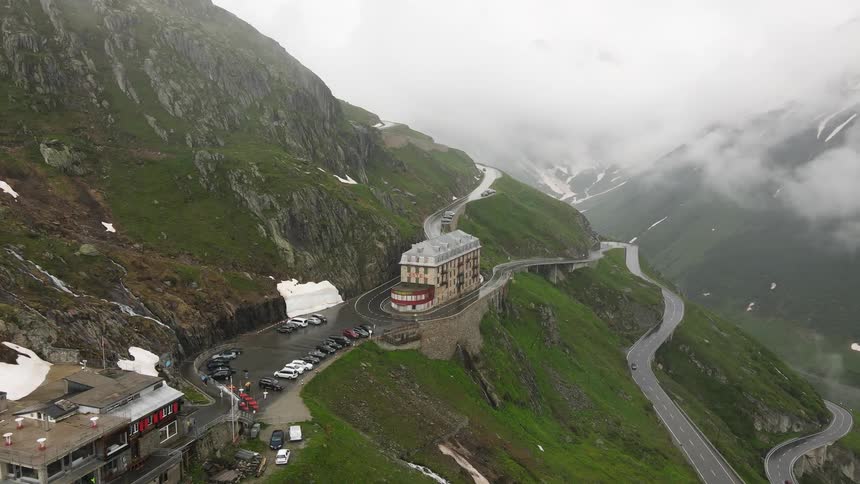 Two hotels sit in on the side of a mountain on a foggy day