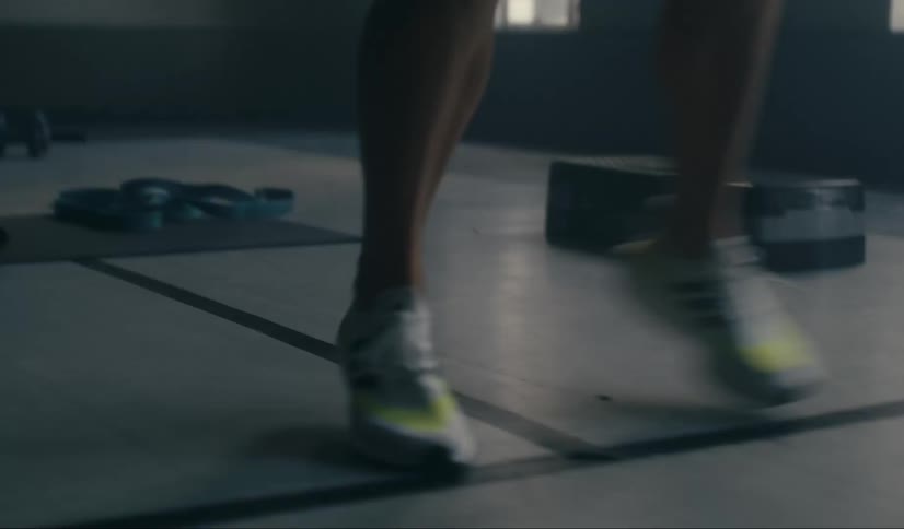 Closeup of a persons legs doing warmup strides indoors