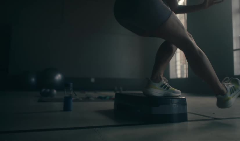 Persons legs on top of a spare tire in a gym room doing balance and stretching exercises