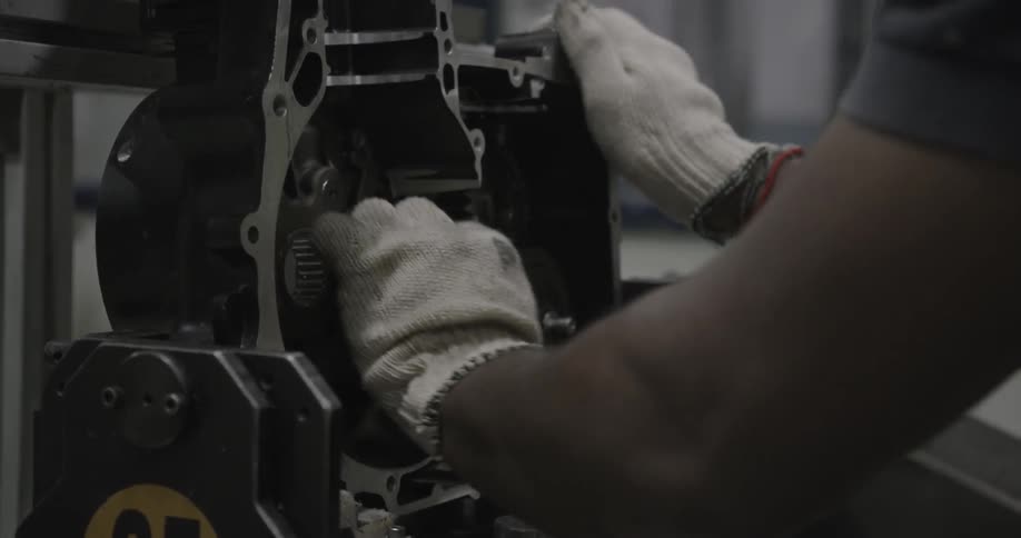 A worker wipes a motorcycle part