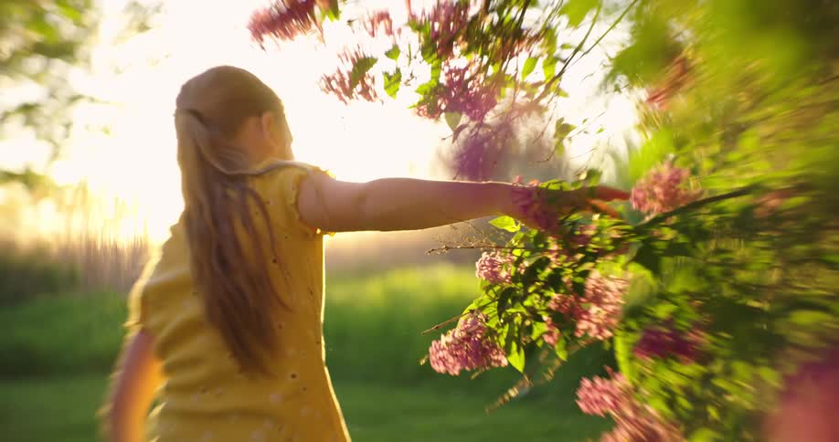 Blonde girl in a field with flowers and the reflection of sunlight