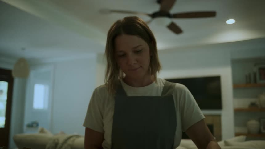 A young woman wipes down her kitchen countertop at home