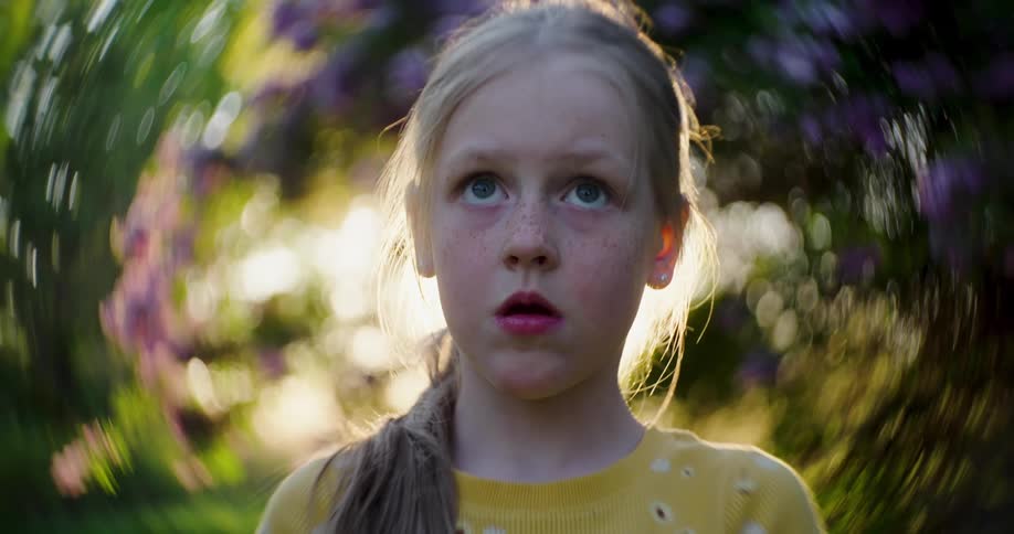 Young girl looks up while an expression of worry or fear washes over her