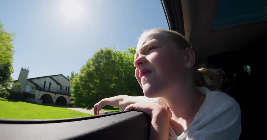 A child is riding in the backseat of a car