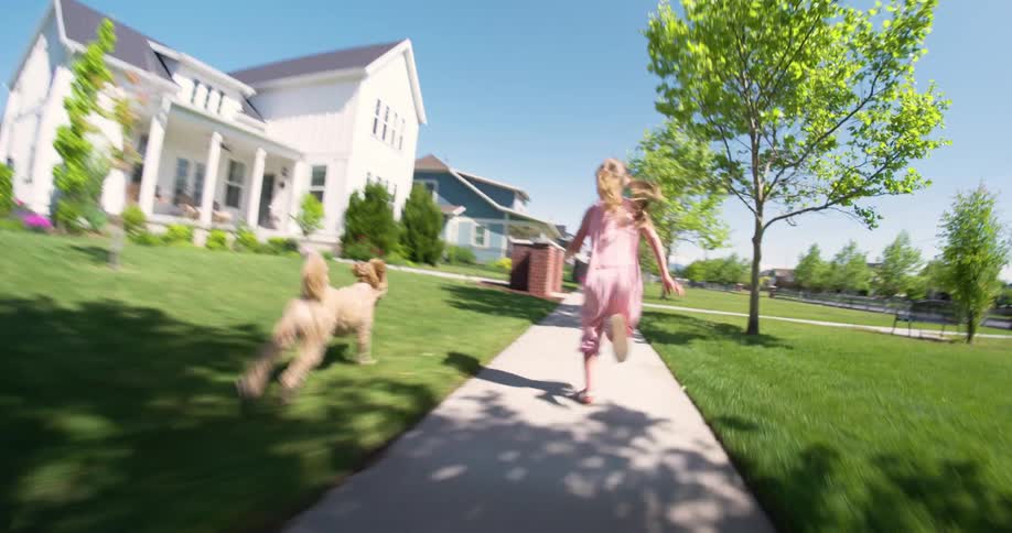Child running on a concrete path with a dog