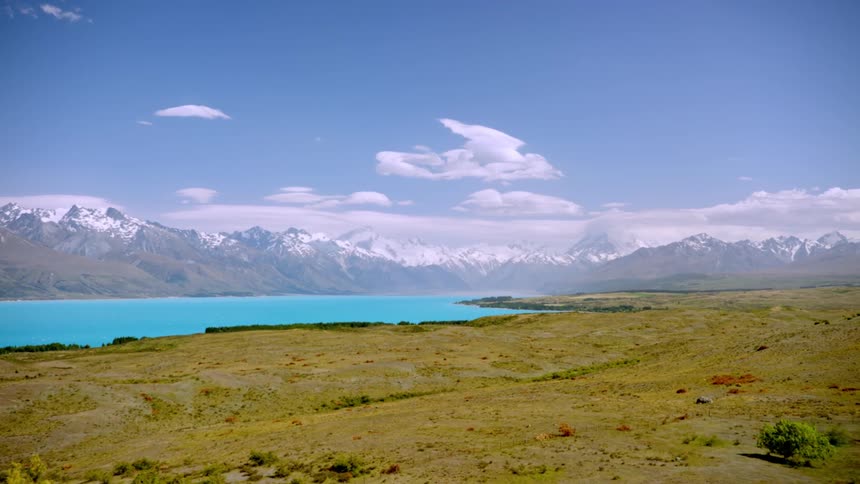 Blue lake surrounded by snow capped mountains during the day
