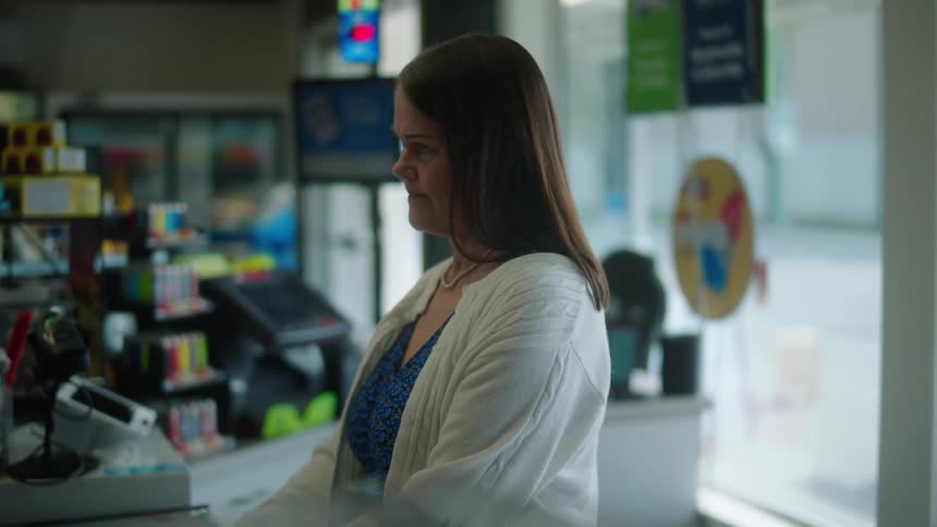 Woman behind a counter in a commercial environment shaking her head