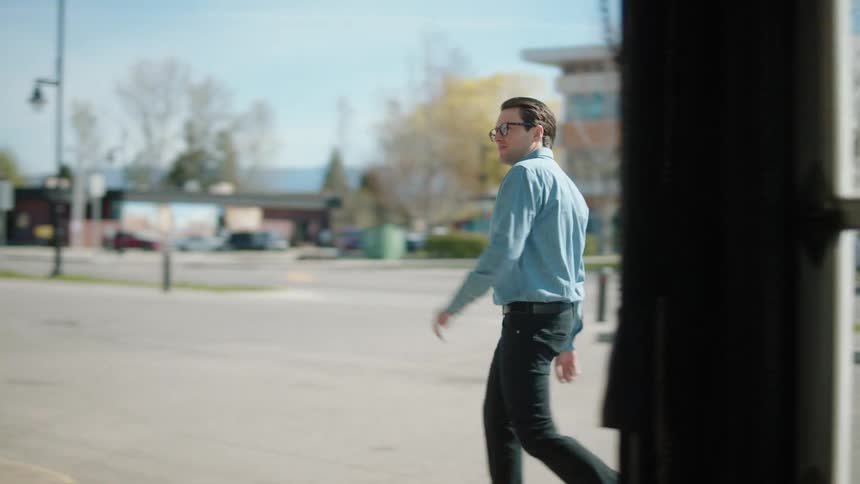 Man entering a business and a woman cleaning a car
