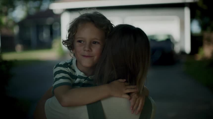 Boy running towards his mother and giving her a hug