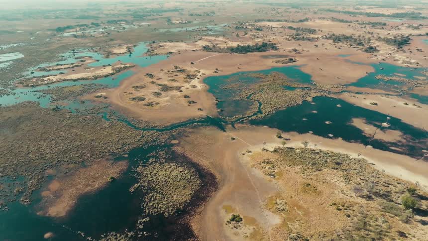 Aerial panorama of land surrounded by lakes in a jungle