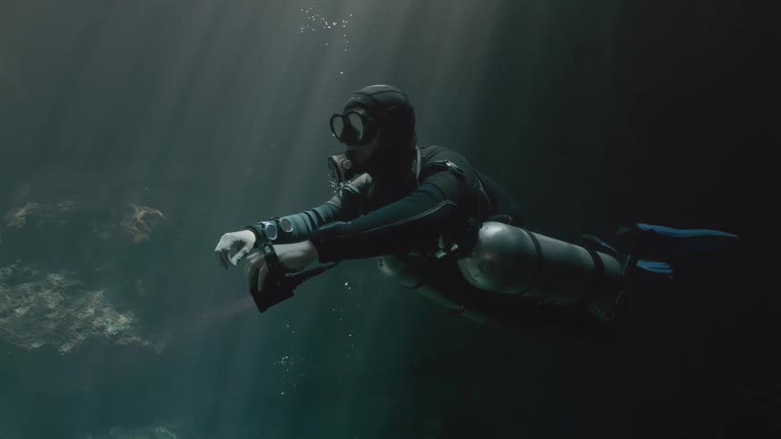 Diver using a red light swimming in the sea