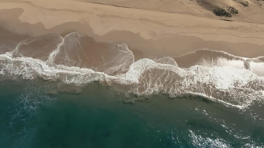 Aerial panorama of a turquoise blue beach and a long stretch of sand
