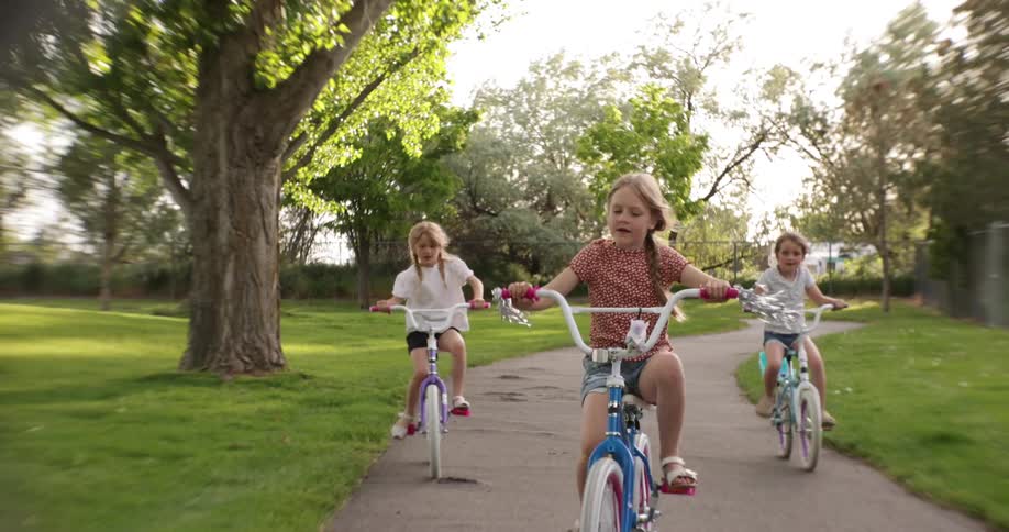 Three girls ride their bikes