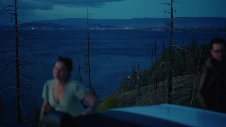 Couple sitting watching nature by the sea at dusk and getting up