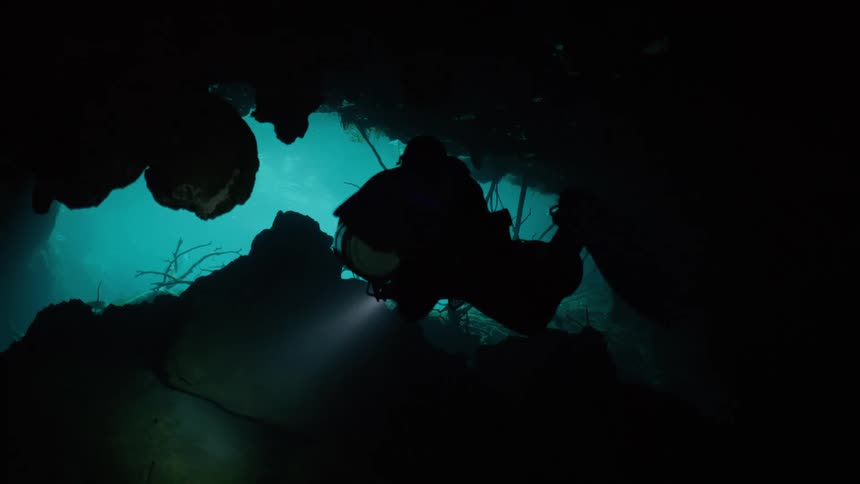 Silhouette of a diver venturing into underwater caves