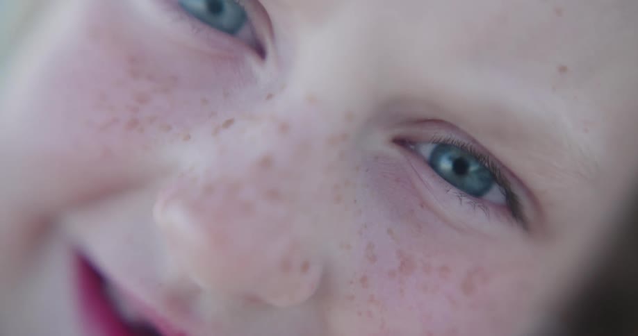 Portrait of the face of a small blonde child with clear eyes and a happy facial expression
