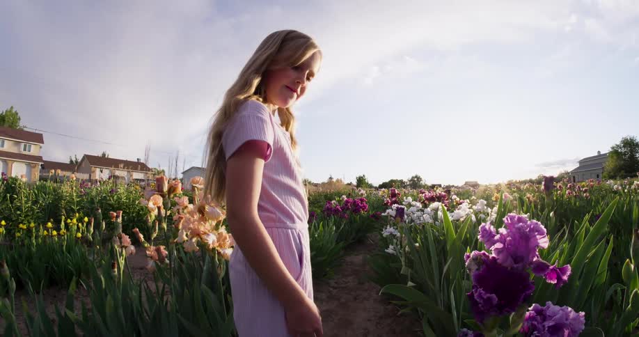 Blonde girl walking in a flower garden