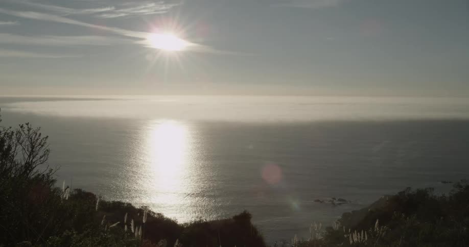 Setting sun shining over ocean water