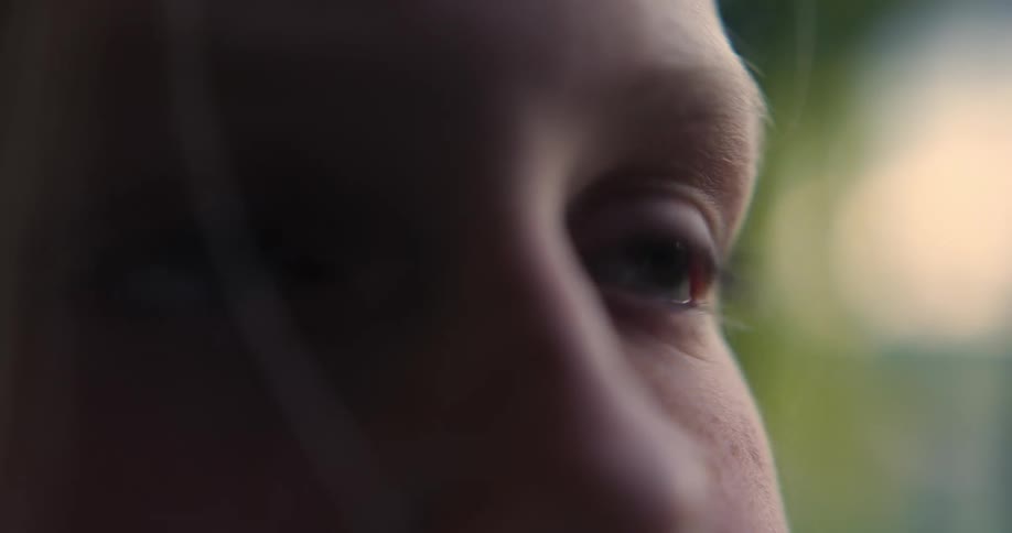 Extreme close up on a young blonde girls eyes as she looks up