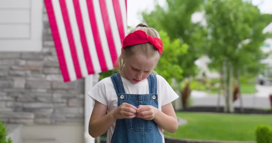 Blonde girl holding an object with her hands with the USA flag in the background